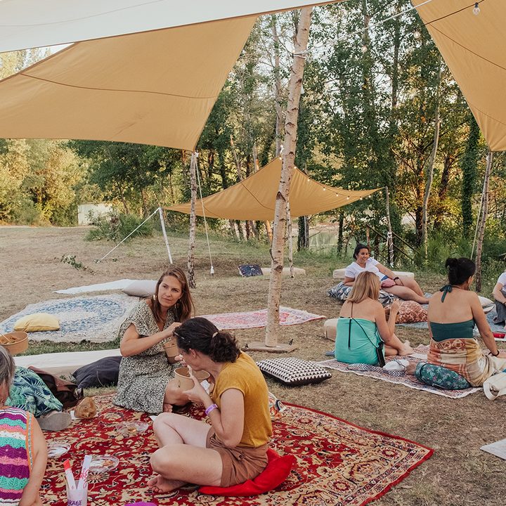 Espace chill du festival avec tapis et ombrage